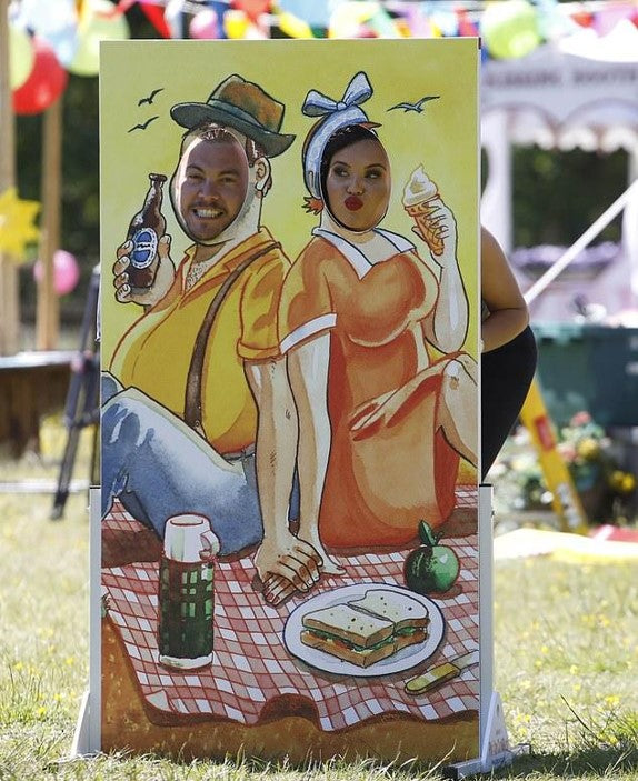 Betty and Billy face in the hole board in use outdoors at an event