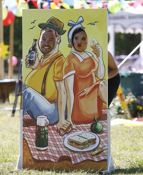 Betty and Billy face in the hole board in use outdoors at an event