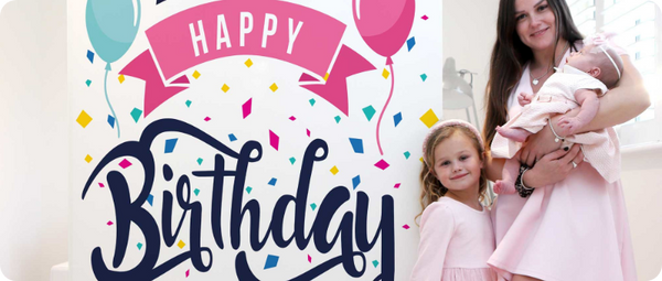 Mother and two children posing next to a custom 6ft  "Happy Birthday" card.
